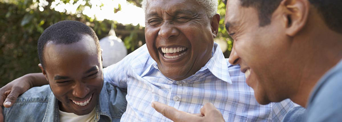 Three friends in a park setting sharing a good laugh together happy with their dentures repairs and relines